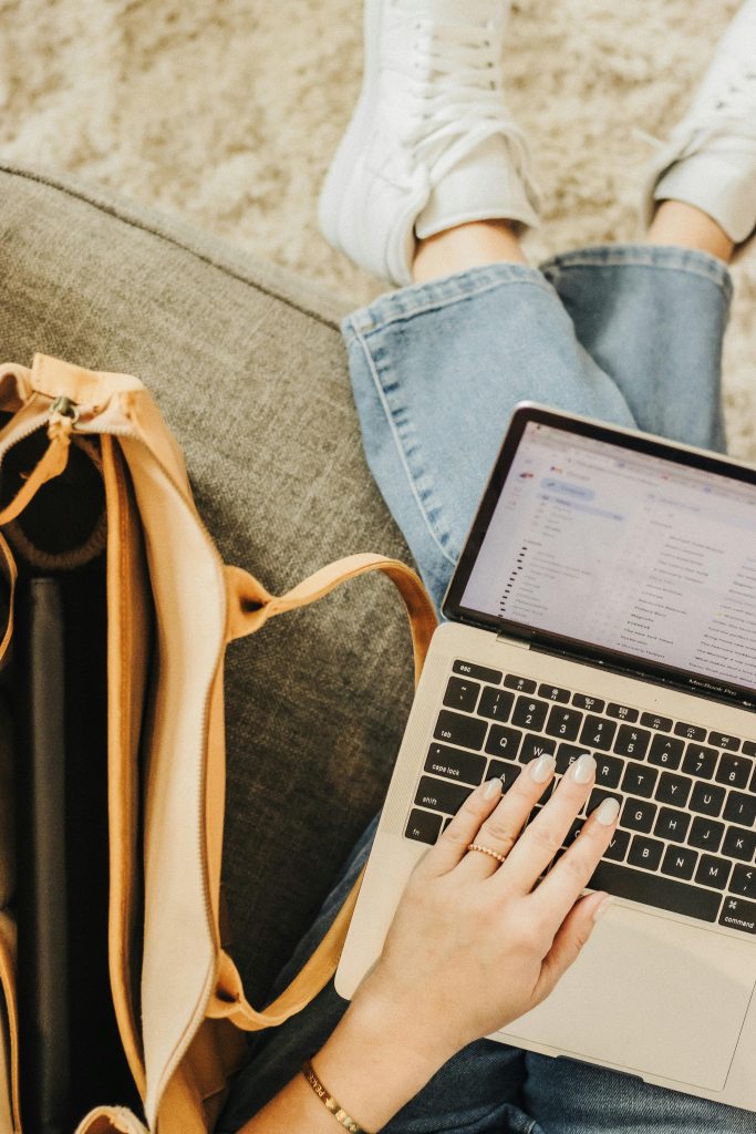pexels photo 29359827 29359827 A person using a laptop with an elegant tote bag nearby in a casual setting.